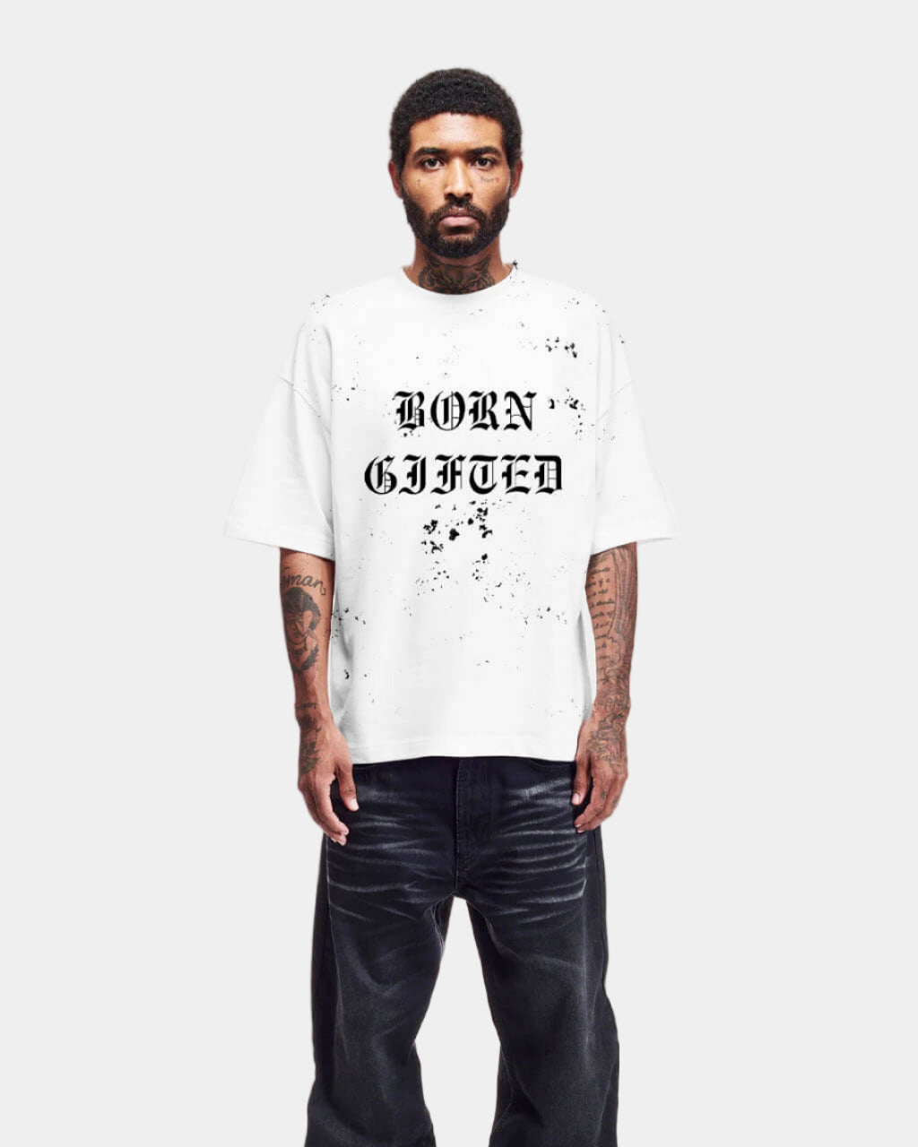 Person wearing a white t-shirt with 'BORN GIFTED' text on a plain background