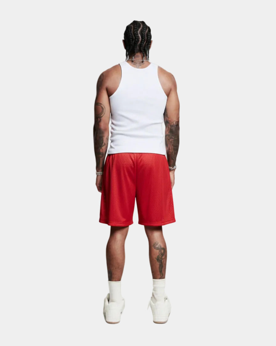 Person wearing a white tank top and red shorts on a white background