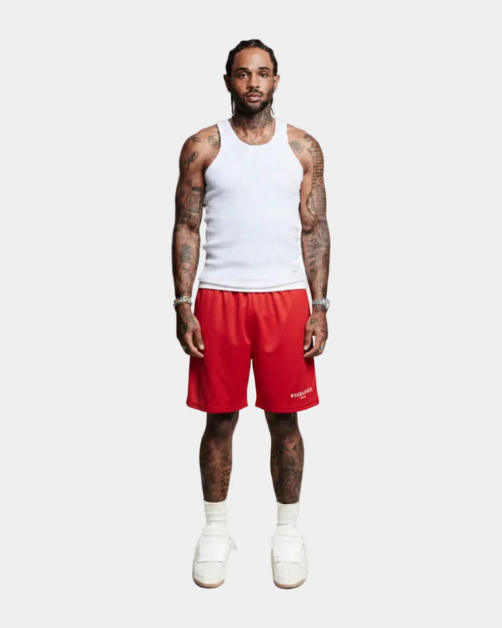 Person wearing a white tank top and red shorts on a white background