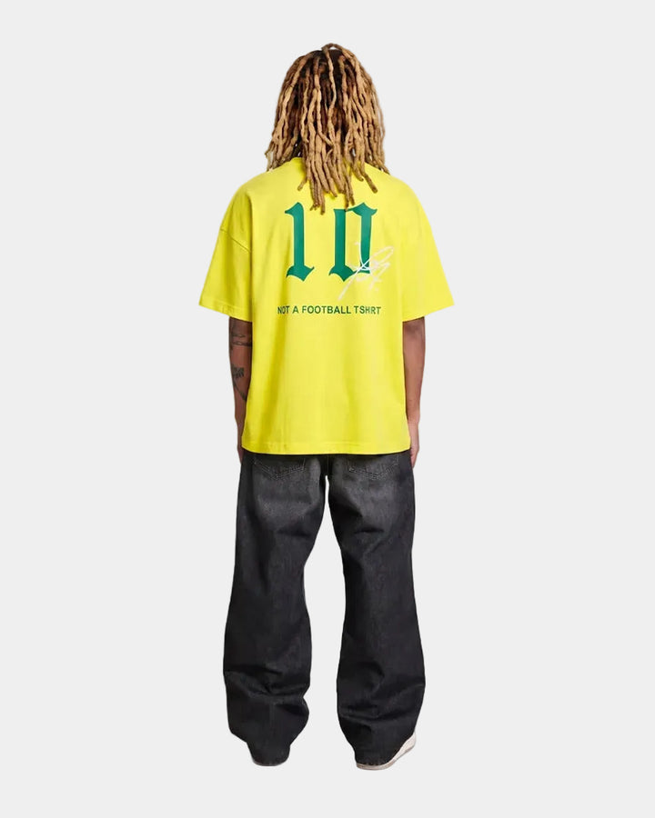 model wearing a Brazil yellow oversized t-shirt with text and graphics on a light grey background
